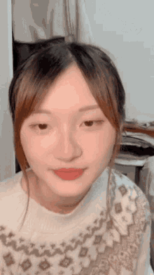 a close up of a woman 's face with a sweater on .