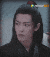 a close up of a man 's face with chinese writing on the bottom left