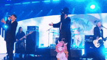 a group of people are standing on a stage playing instruments .