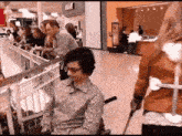 a man in a wheelchair is being pushed by a woman in a store
