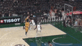 a basketball game is being played in front of a tissot advertisement
