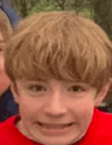 a close up of a young boy 's face making a funny face .