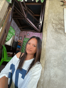 a girl wearing a white shirt with a blue t on it