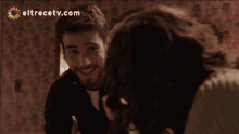 a man and woman are smiling in front of a eltrecetv.com logo