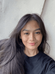 a woman wearing a black shirt is smiling for the camera