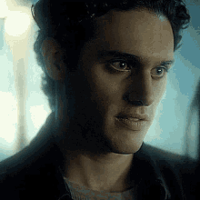 a close up of a man 's face in a dark room with a blue background .