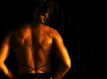 a woman with curly hair is wearing a black bikini