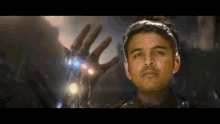 a man wearing a headband is holding up his hand with the infinity gauntlet