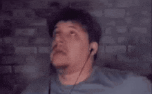 a man is wearing headphones and praying with his hands in the air .