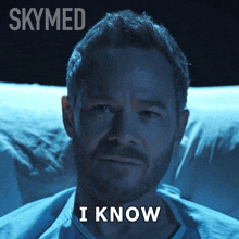 a man in a hospital bed with the words i know written on his face