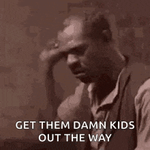 a man is holding his hand to his forehead and saying `` get them damn kids out the way `` .