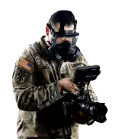 a man in a us army uniform is holding a camera and wearing a gas mask