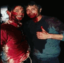 a man with blood on his face giving a thumbs up next to another man