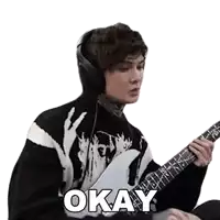 a man wearing headphones is playing a guitar and the word okay is on the screen .