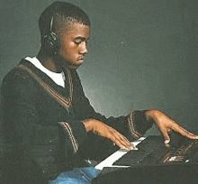 a young man is wearing headphones and playing a piano .