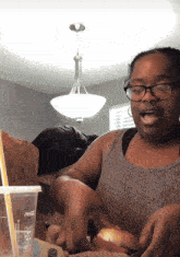 a woman eating a hamburger next to a coca cola cup with a straw