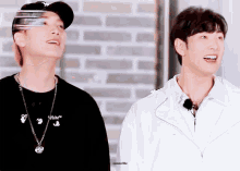 two men are standing next to each other with one wearing a black shirt that says " white "