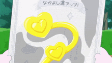 a person is holding a piece of paper with a picture of two yellow hearts on it