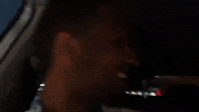 a man is sitting in the back seat of a car with his mouth open .