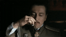 a man in a military uniform has a medal around his neck with a cross on it