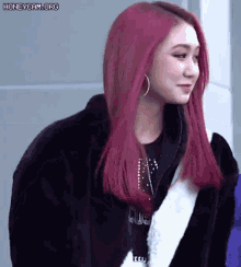 a girl with red hair is wearing a fur coat and earrings .