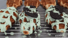 a bunch of oreo cookies covered in mint icing on a cooling rack