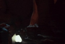 a man with a beard holds his fist up in the air in a dark room
