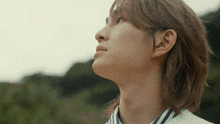 a close up of a person 's face with a striped shirt on