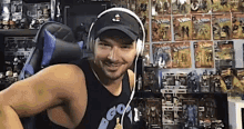 a man wearing headphones is sitting in a chair in front of a wall of action figures .