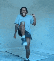 a man wearing headphones and shorts jumps in the air
