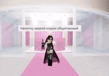 a woman in a black dress is standing on a pink carpet in front of a sign that says kalitku