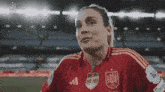 a woman wearing a red adidas jersey with the number 7 on the front