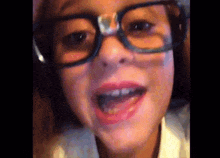 a little girl wearing glasses and a white shirt