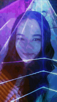 a woman 's face is surrounded by a purple and blue light