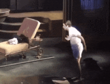 a man is standing on a stage in front of a chair that says ' a ' on the back
