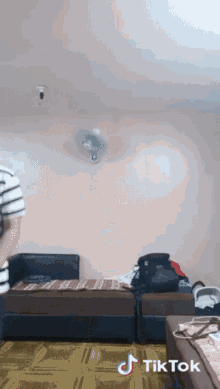 a room with two beds and a fan and a tiktok sticker on the bottom