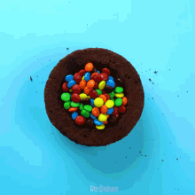 a bowl of m & m 's sits on a blue surface next to the words mr.cakes