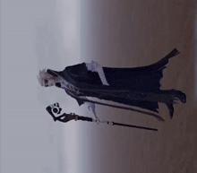 a man in a black cape holding a cane