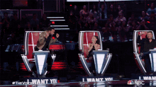 a man is dancing in front of a microphone while a woman applauds behind him on the show the voice