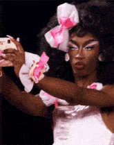 a drag queen taking a selfie with a cell phone