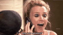 a woman is talking on a cell phone and saying " are you serious " .
