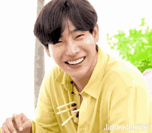 a man in a yellow shirt is smiling with judleklek702 on the bottom