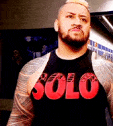 a man is wearing a black tank top that says solo on it