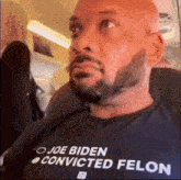 a man wearing a shirt that says joe biden convicted felon on it