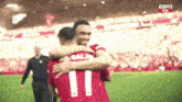 two soccer players hugging with the number 11 on their jerseys