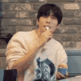 a man in a white shirt is eating ice cream