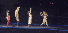 a group of women are standing on a stage holding microphones and singing into them .