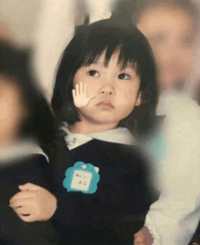 a little girl wearing a name tag that says ' みな ' on it