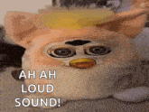 a close up of a furby doll with the words `` ah ah loud sound '' written above it .