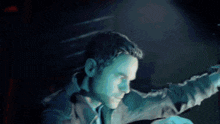 a man is standing in a dark room holding a gun in his hand .